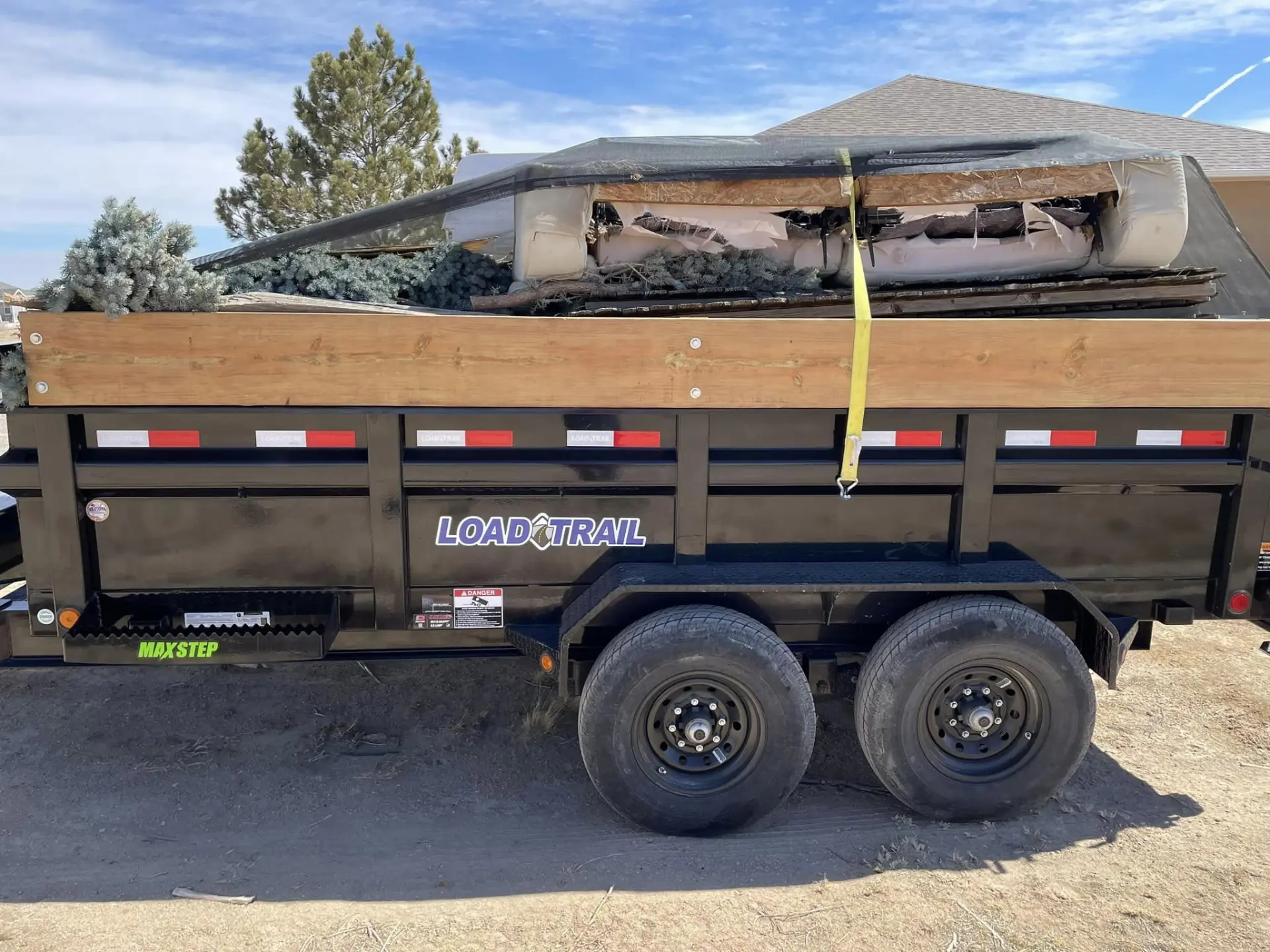Dump trailer loaded with yard waste and brush after a cleanup