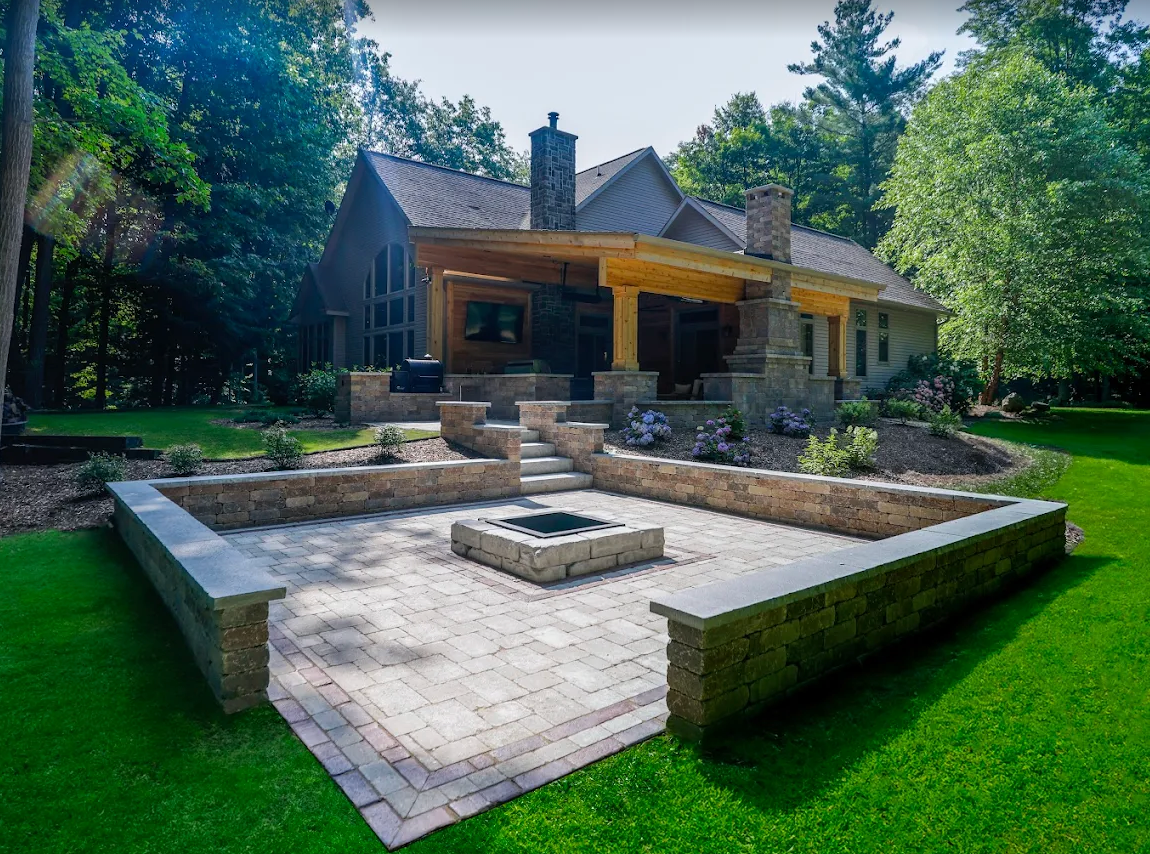 Sunken paver patio with block seating walls and a square fire pit