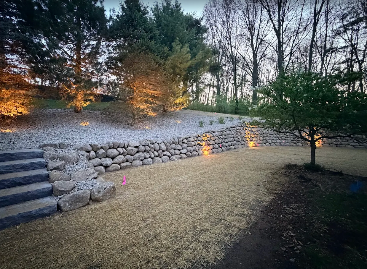 Natural boulder retaining wall with stone steps and gravel bed